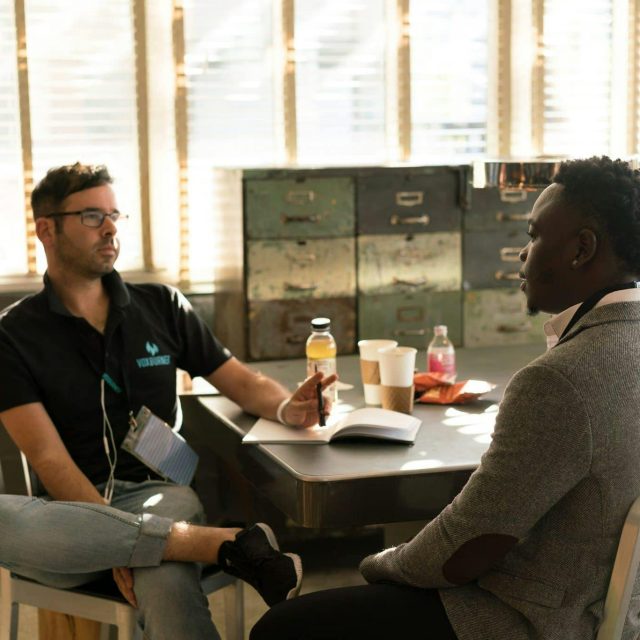Two men having a focused business discussion in a sunlit office space.